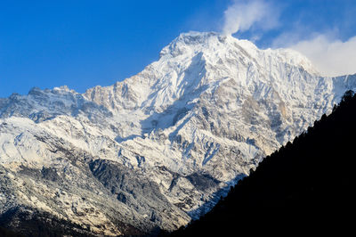 Low angle view of snowcapped mountains against sky