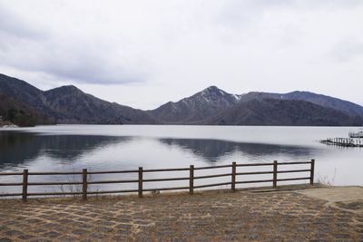 Scenic view of lake by mountains against sky