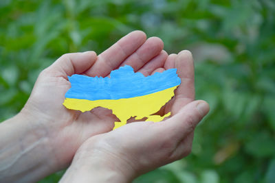 Cropped hand of woman holding yellow flower