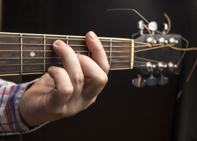 Midsection of man playing guitar