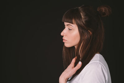 Portrait of woman against black background