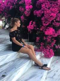 Woman looking away while sitting on plant