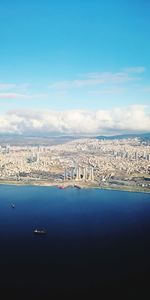 Aerial view of city by sea against sky