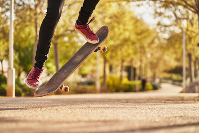 Low section of person skateboarding on road