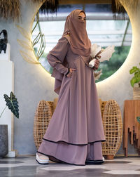 A beautiful asian woman wearing a stylish hijab and abaya fashion clothing with headscarf and veil