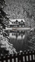 Houses by lake and buildings during winter