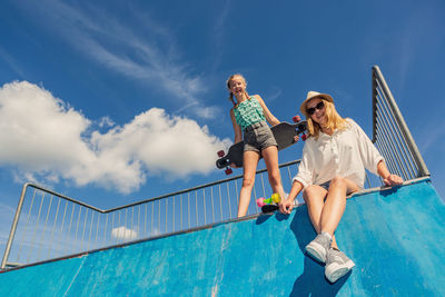 Low angle portrait of siblings at skateboard park