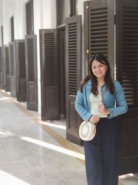 Low angle view of young woman standing against building