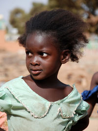 Close-up of girl looking away while standing outdoors