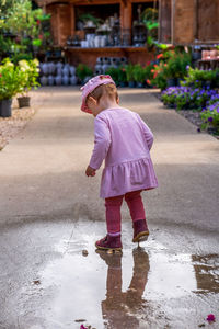 A small child is playing in a rain puddle