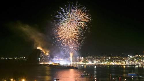 Firework display over river at night