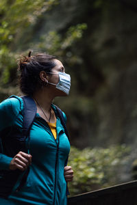 Midsection of woman standing by tree in forest