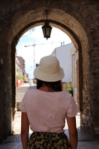 Side view of woman looking through window