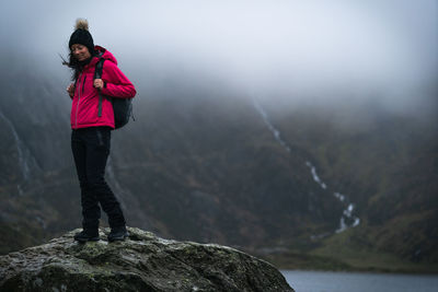 Full length of man standing on rock against mountains