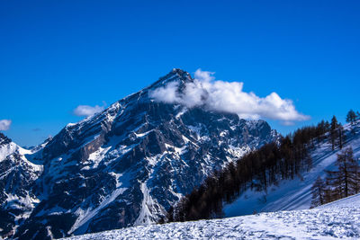 Snow covered mountain against blue sky