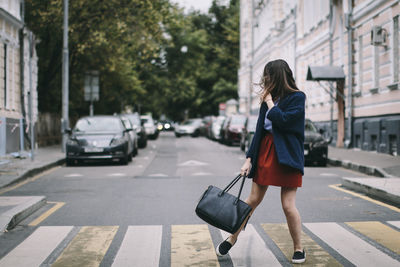 Woman with umbrella on street in city