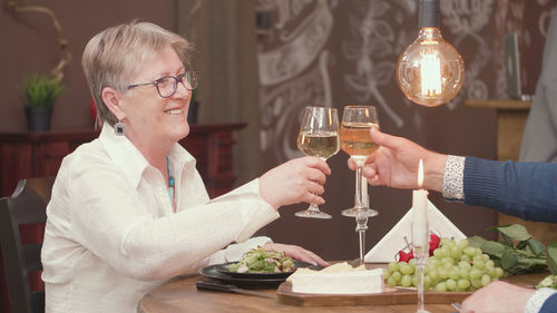 Smiling friends toasting wineglasses at home