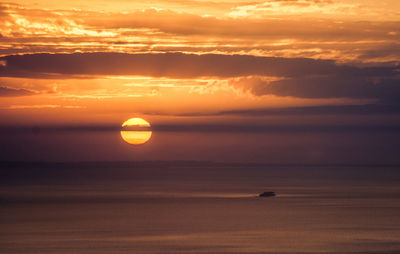 Scenic view of sea against romantic sky at sunset