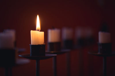 Close-up of lit candle in darkroom