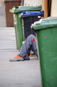 Low section of man relaxing on table by street