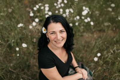 Portrait of smiling mature woman sitting on field