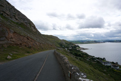 Road by mountain against sky