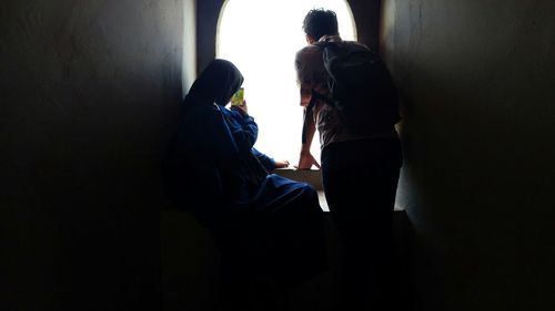 Rear view of couple standing in dark room