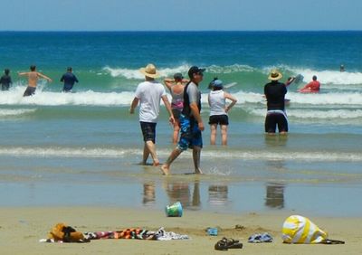 Rear view of people standing on beach