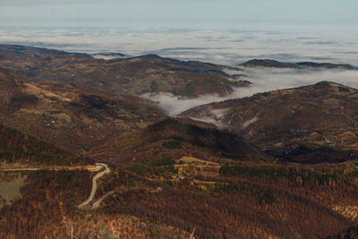 High angle view of land  and fog against sky