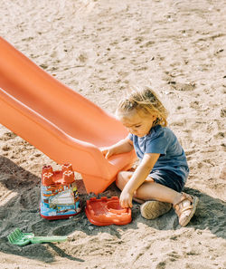 High angle view of girl playing with toy on sand