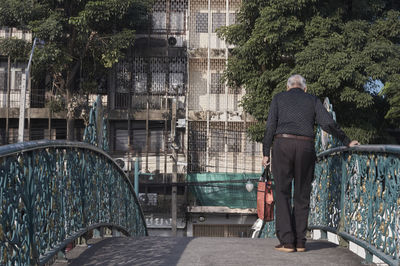 Rear view of old man on bridge