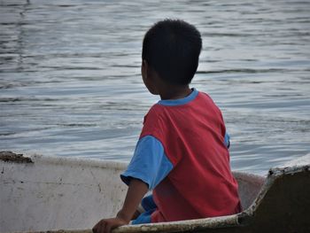 Rear view of boy sitting on beach