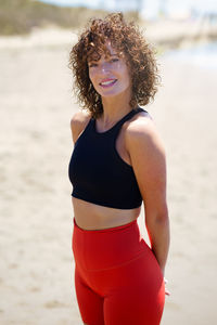 Portrait of young woman standing at beach