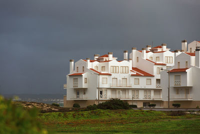 Residential buildings by sea against sky