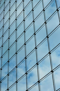 Low angle view of glass building against sky