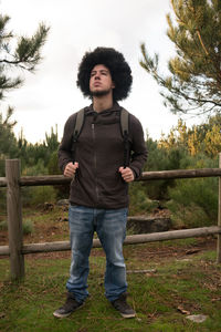 Portrait of young man standing against plants