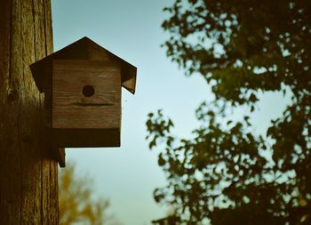 Low angle view of birdhouse on tree against sky