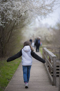 Rear view of woman walking on footbridge