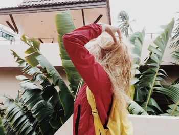 Side view of backpack woman with hand in hair standing on steps