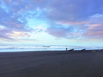 Scenic view of beach against cloudy sky