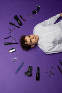 High angle view of hairdresser lying on blue background