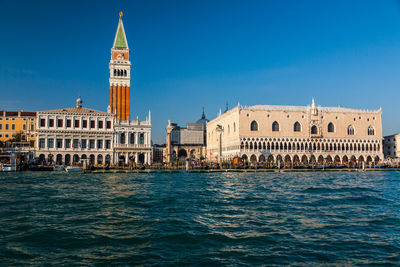 St marks square by grand canal against clear blue sky in city