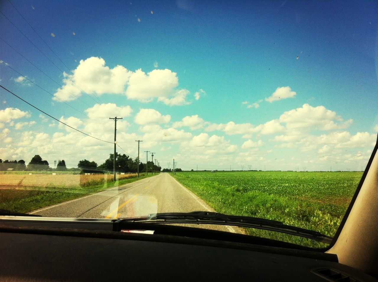 transportation, sky, landscape, vehicle interior, road, field, rural scene, mode of transport, the way forward, windshield, country road, transparent, glass - material, car, cloud - sky, diminishing perspective, nature, cloud, grass, vanishing point