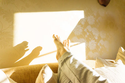 Low section of woman sitting on sofa