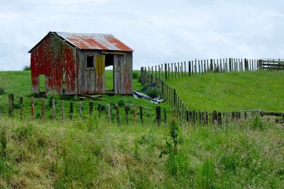 Abandoned house on field against sky