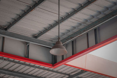 Low angle view of illuminated pendant lights hanging from ceiling of building