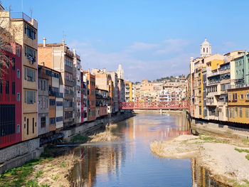 Canal amidst buildings in city against sky