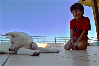 Side view of kid with dog on floor