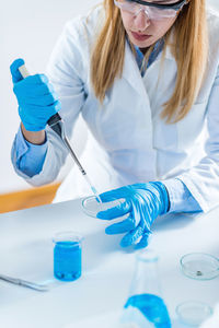 Female scientist examining chemical in laboratory