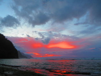 Scenic view of sea against dramatic sky during sunset